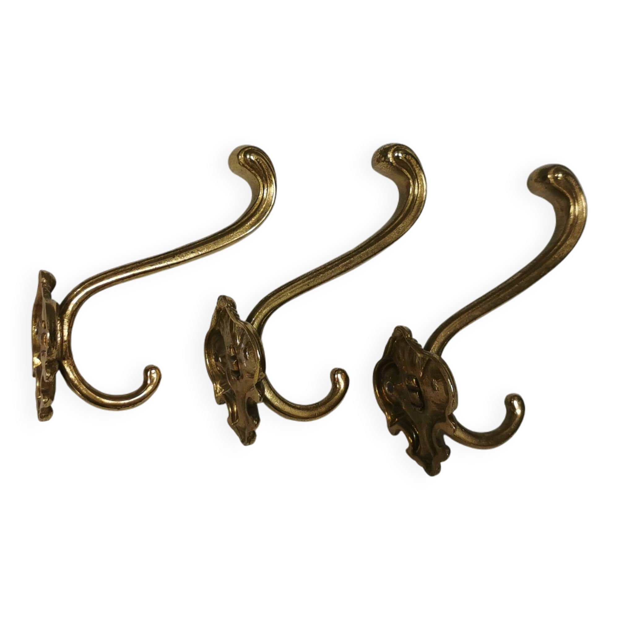 Three old and beautiful brass hooks with decorative motifs