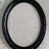Oval frame in black varnished carved wood