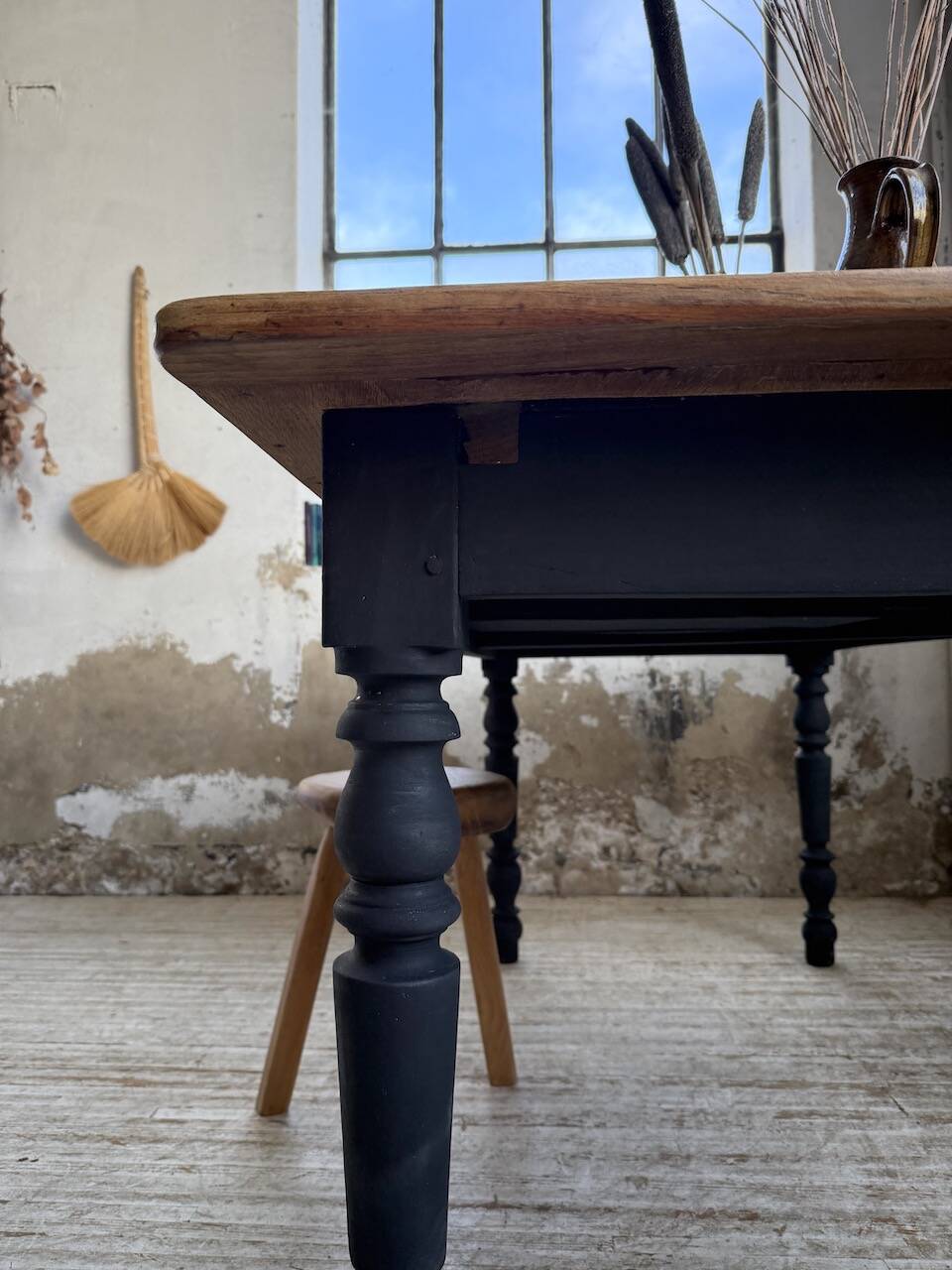 Oak farmhouse table with turned black legs.