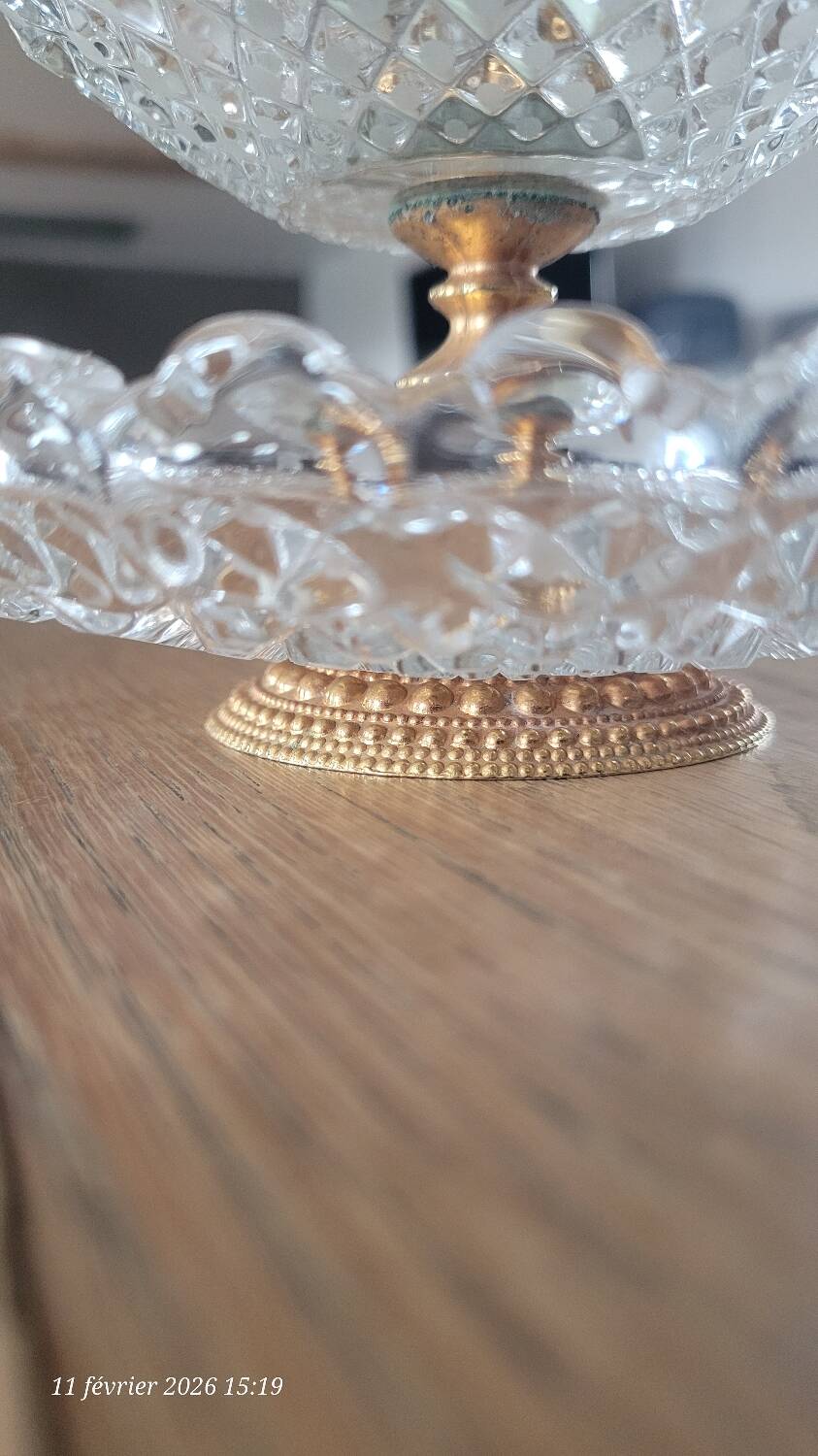 Two-tier display stand in cut glass mounted on a gold metal base.