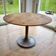 Round wooden table with concrete tulip base