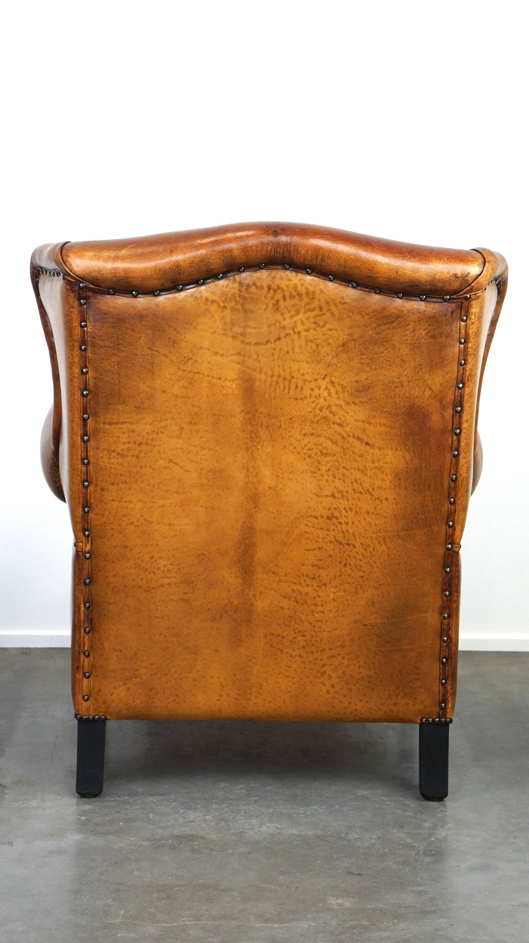 Sheepskin leather wingback armchair, with nails and black piping