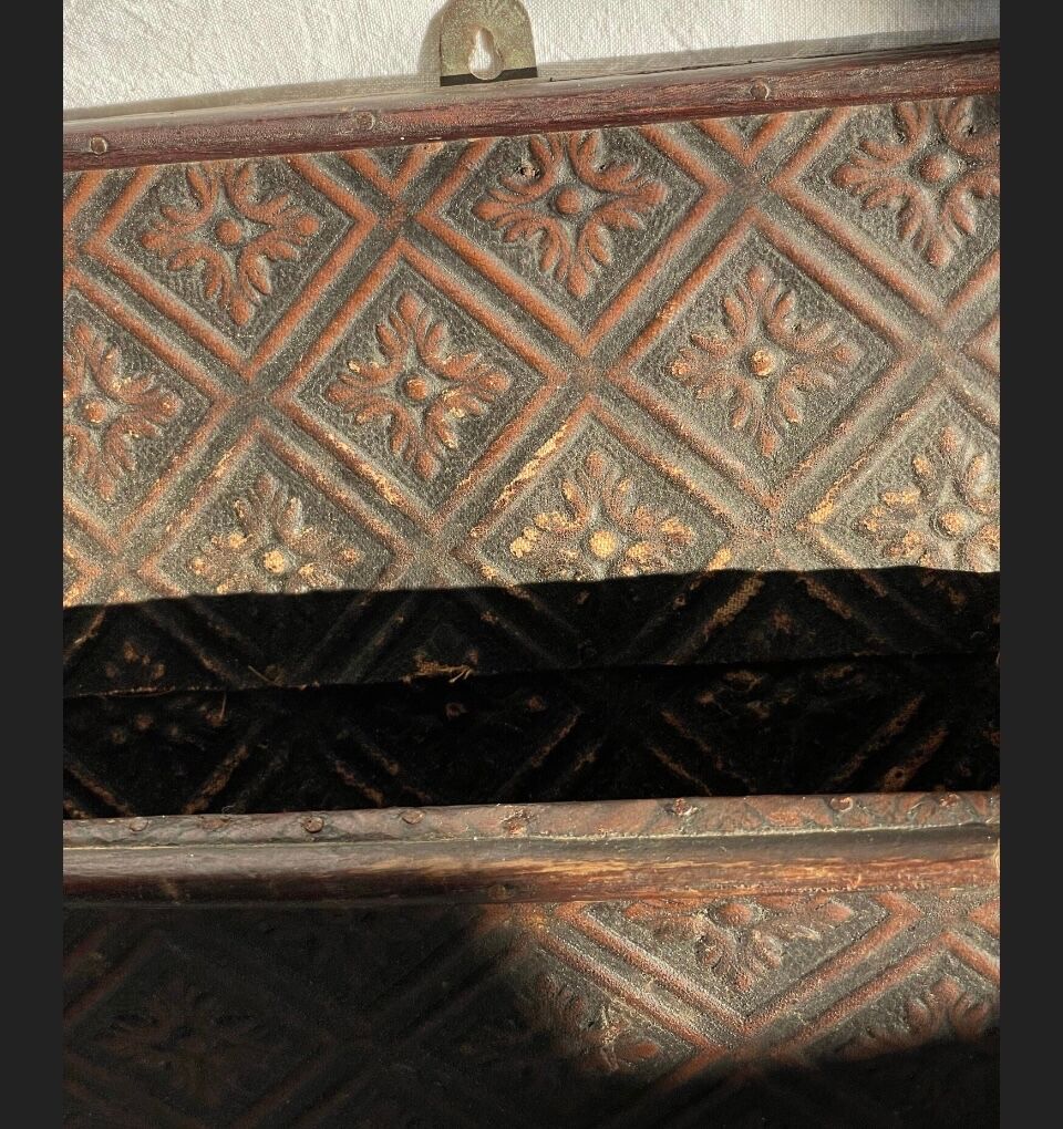 Hammered leather wall mail holder on wood.