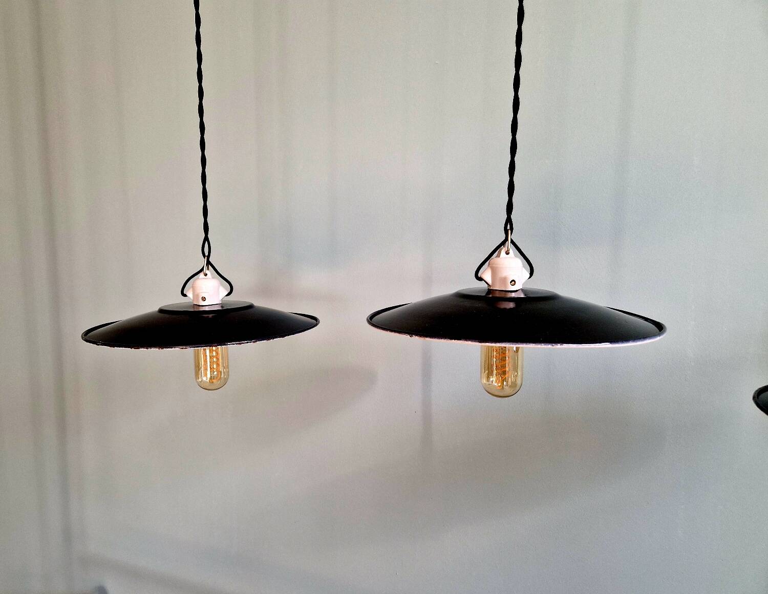 Three industrial suspensions in black enamelled sheet metal.
