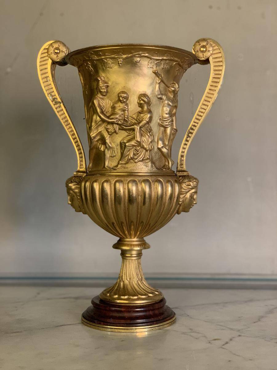 Golden bronze urn, base of red griotte marble.