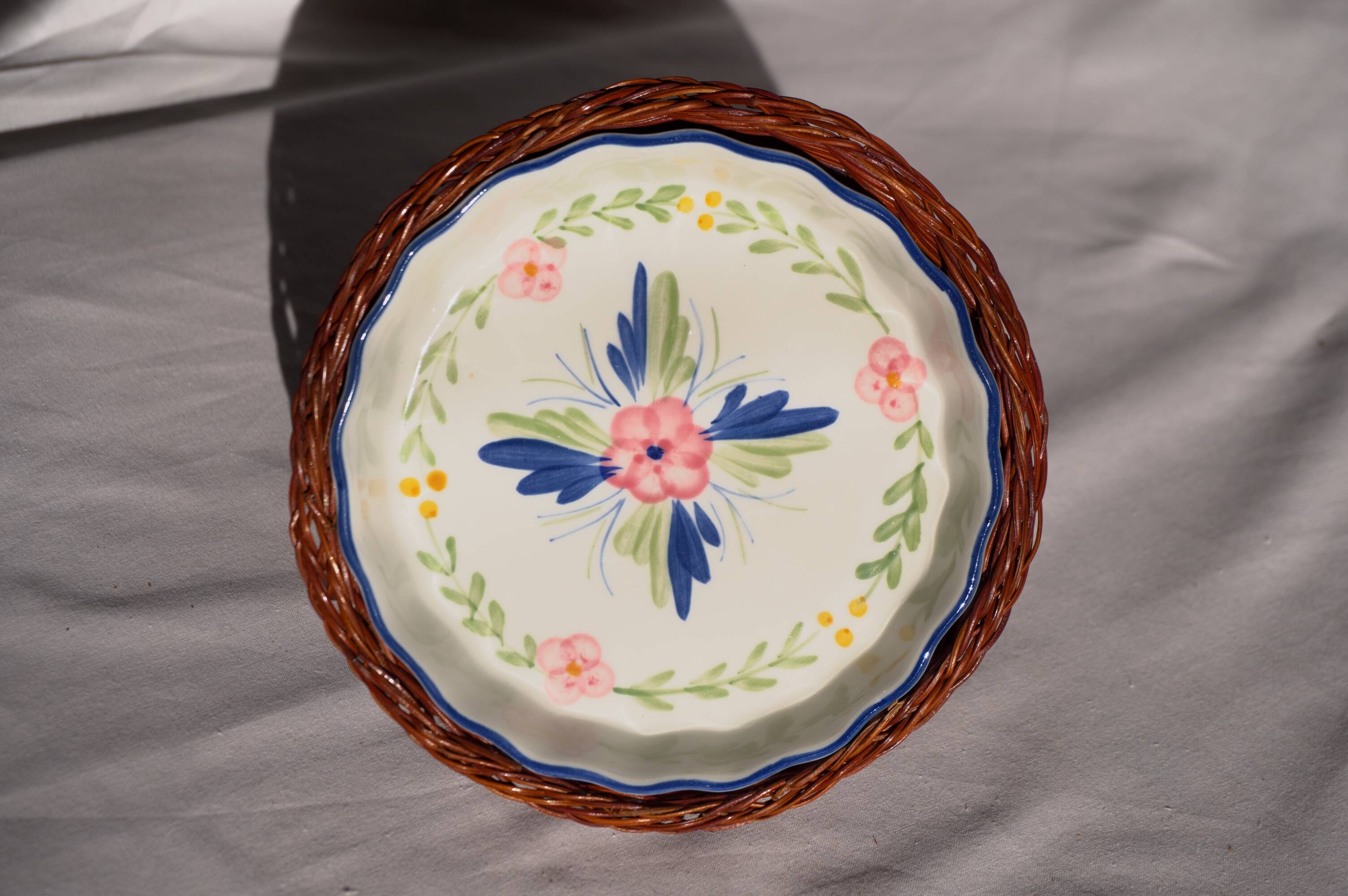 Set of 3 porcelain dishes with floral decorations, with wicker supports.