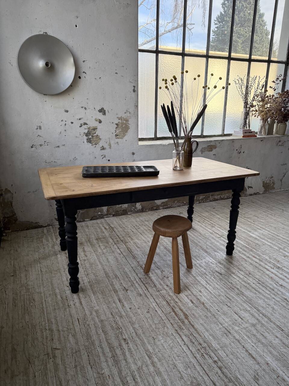 Oak farmhouse table with turned black legs.