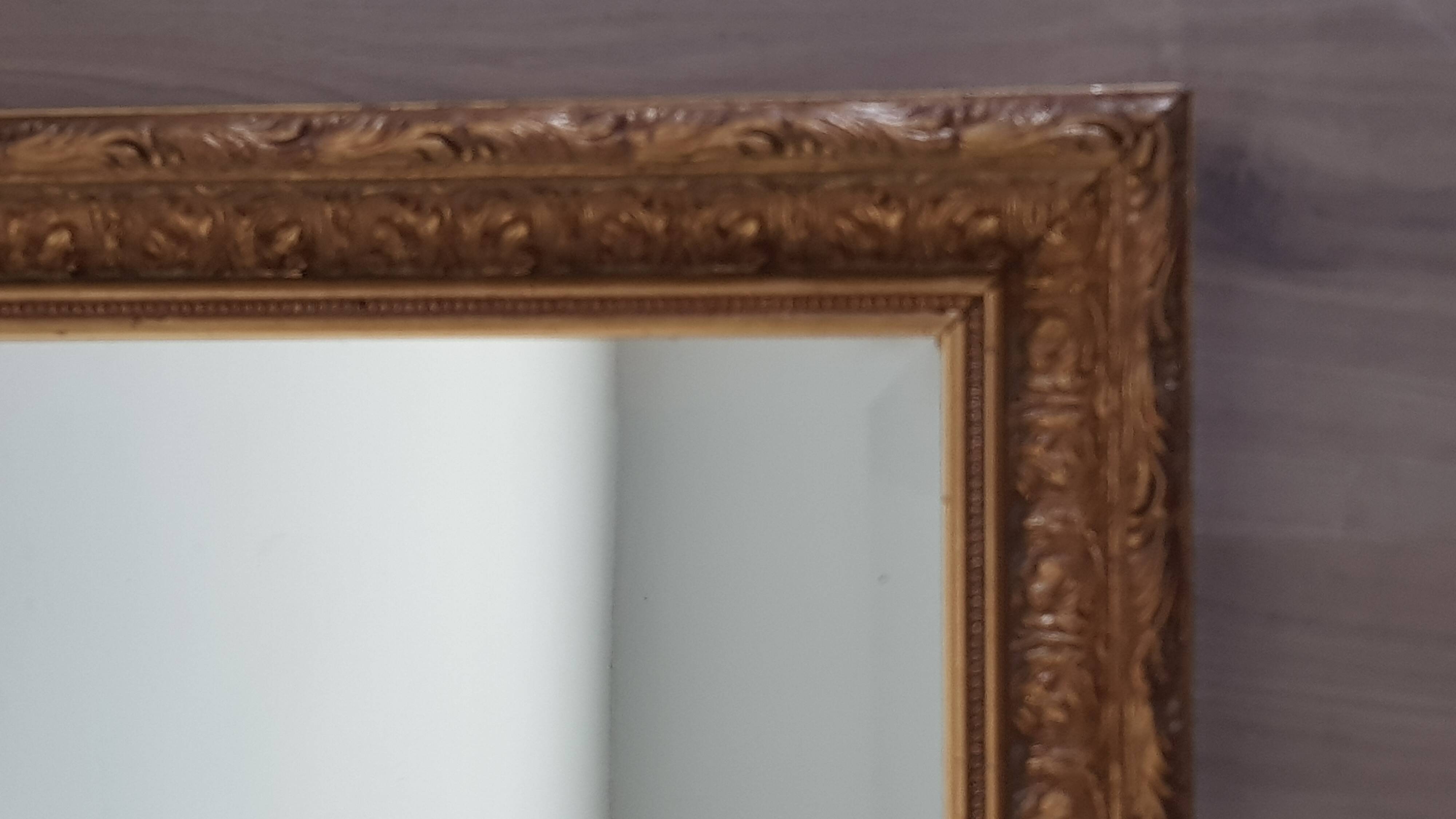 Mirror in gilded stucco wood and beveled glass