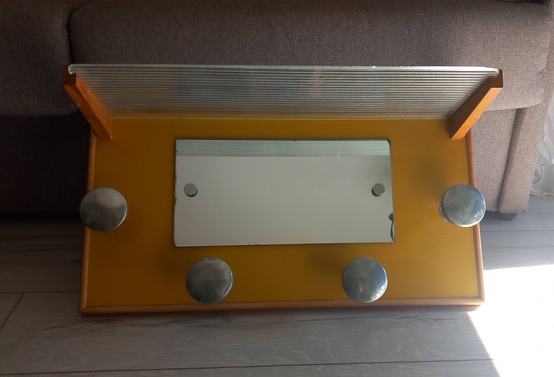 1950s coat rack with mirror, metal hooks, and glass shelf.