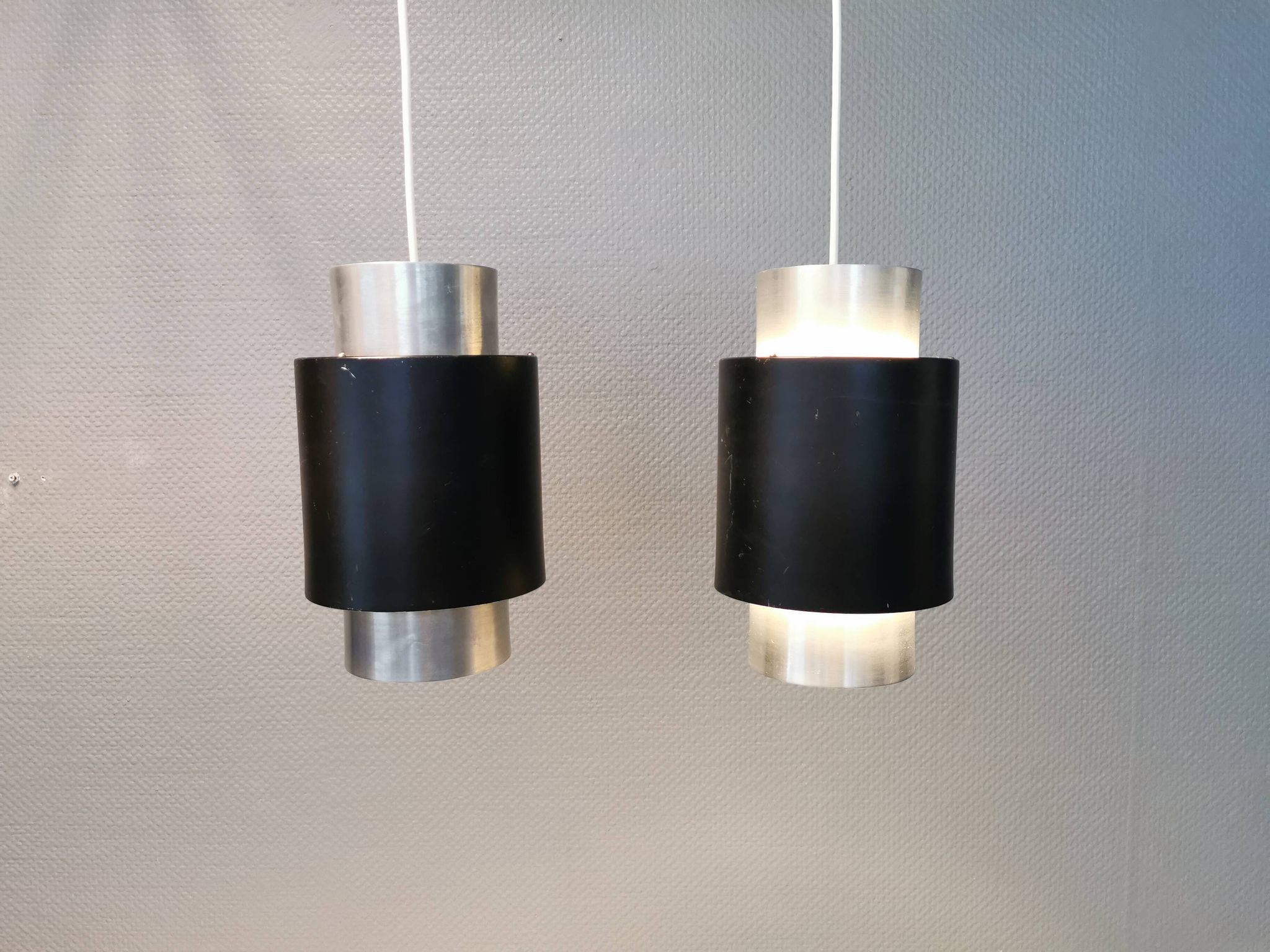 A set of beautiful cylinder shaped hanging lamps in silver color with black "ring" Danish 1970s.