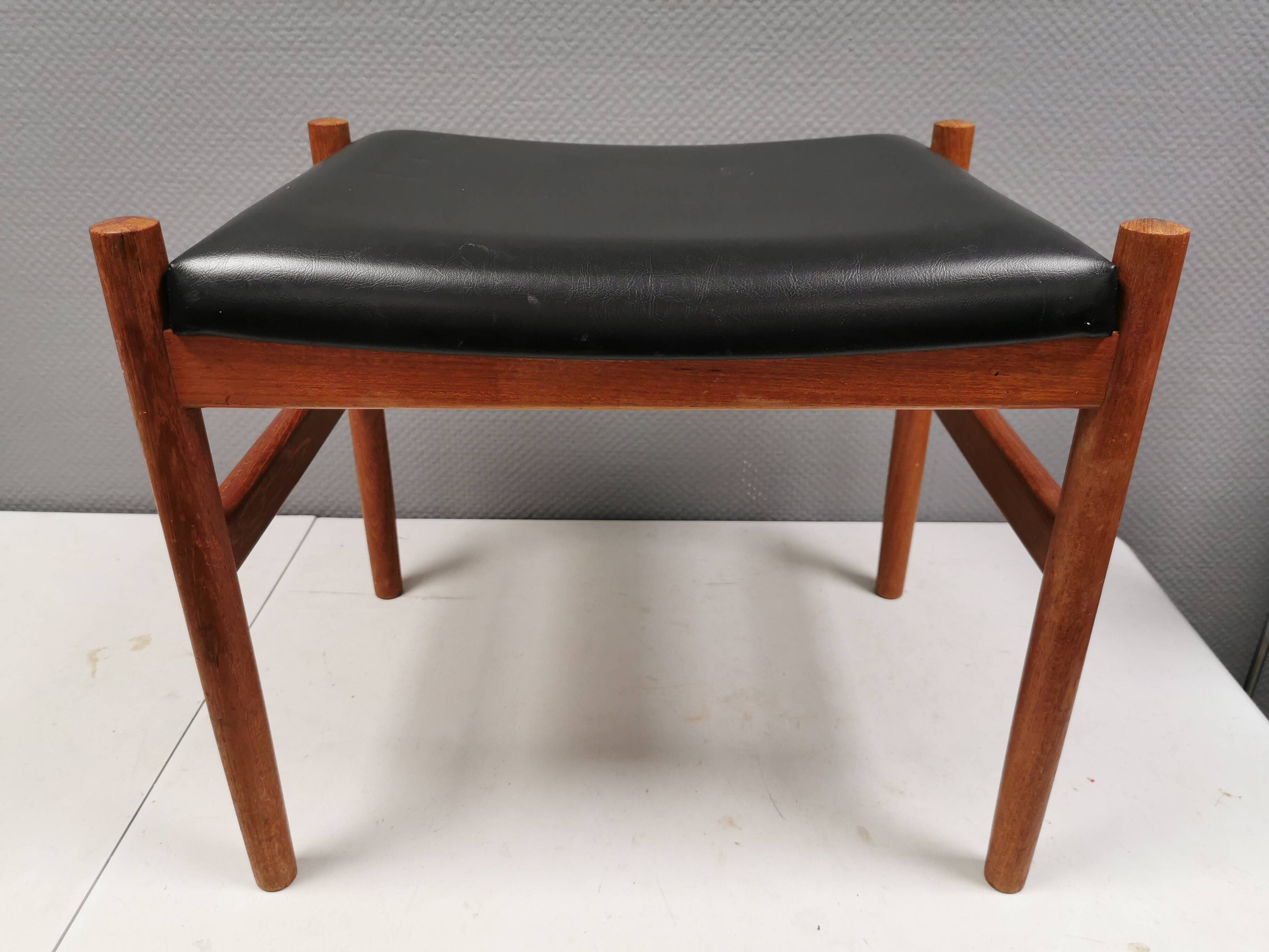 Danish designed footstool in teak wood and black skai “imitation leather”