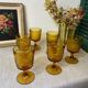 Six amber-colored stemmed glasses
