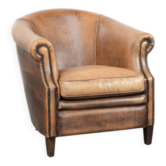 Club chair made of sheepskin leather finished with decorative nails