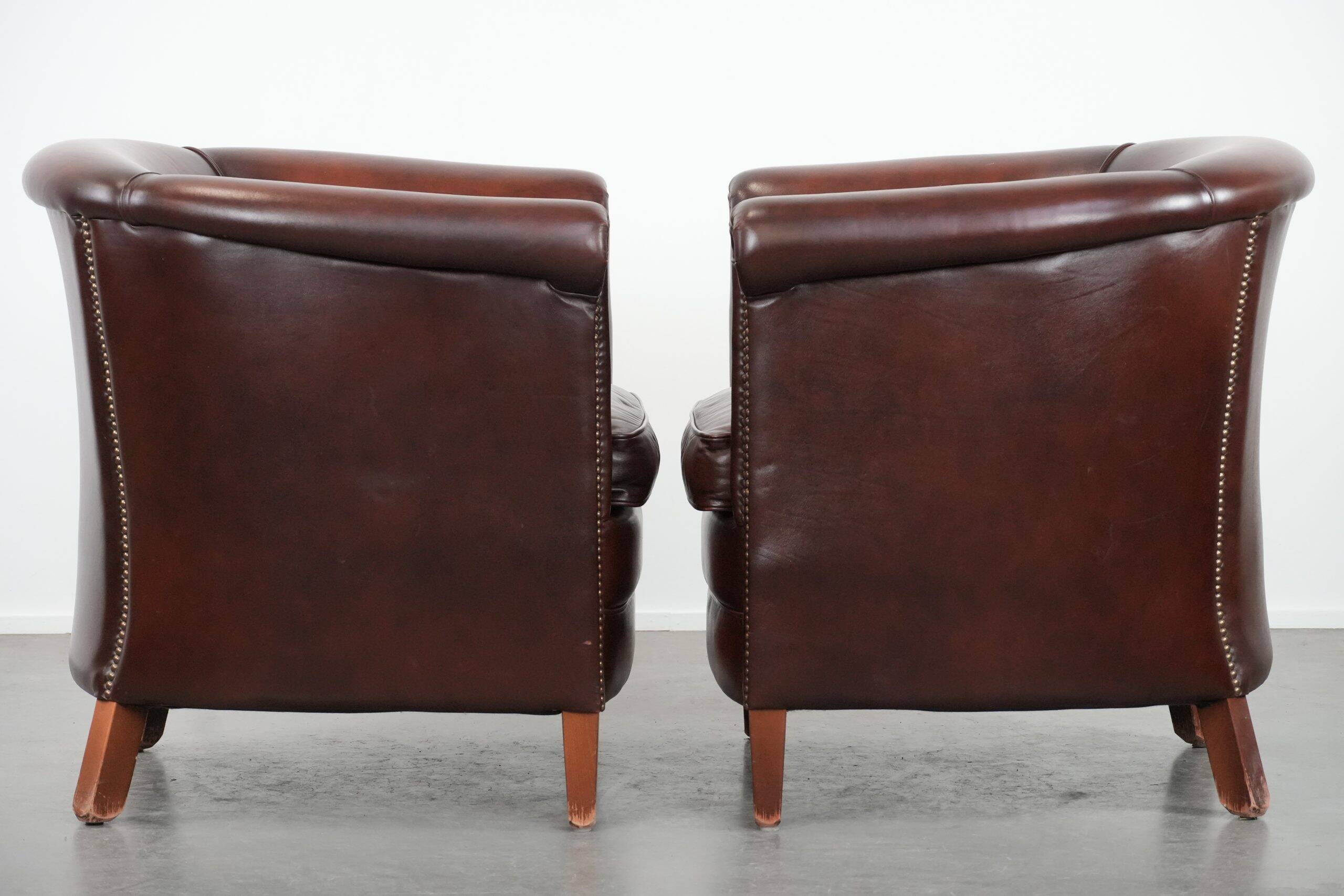 Set of two cow leather club armchairs in a luxurious red/brown colour