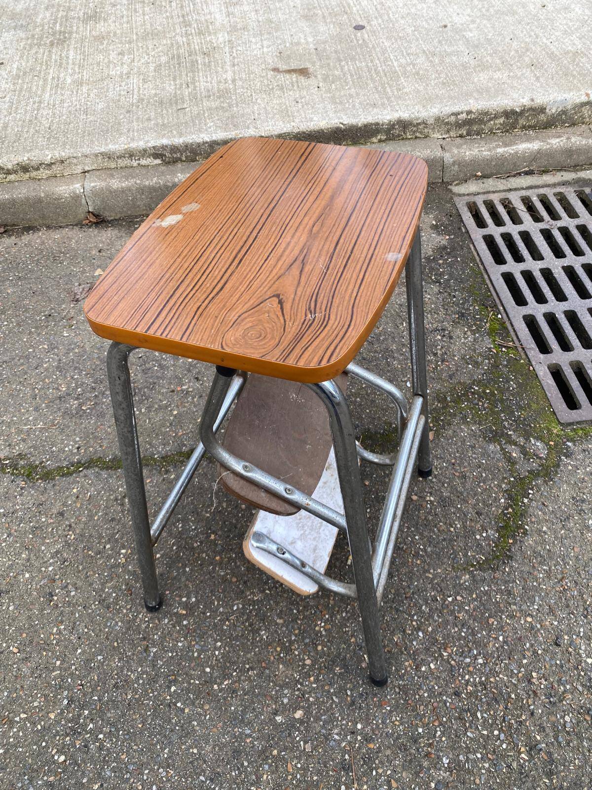 Folding stool in formica with a wood effect.