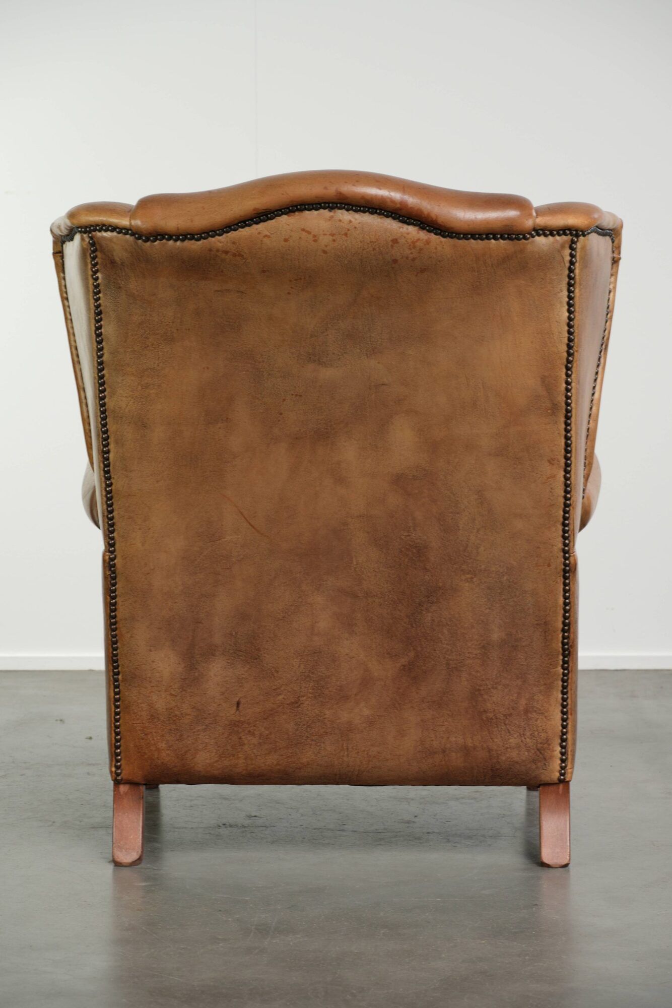 Sheepskin wingback armchair in a light cognac colour in English style