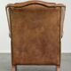 Sheepskin wingback armchair in a light cognac colour in English style
