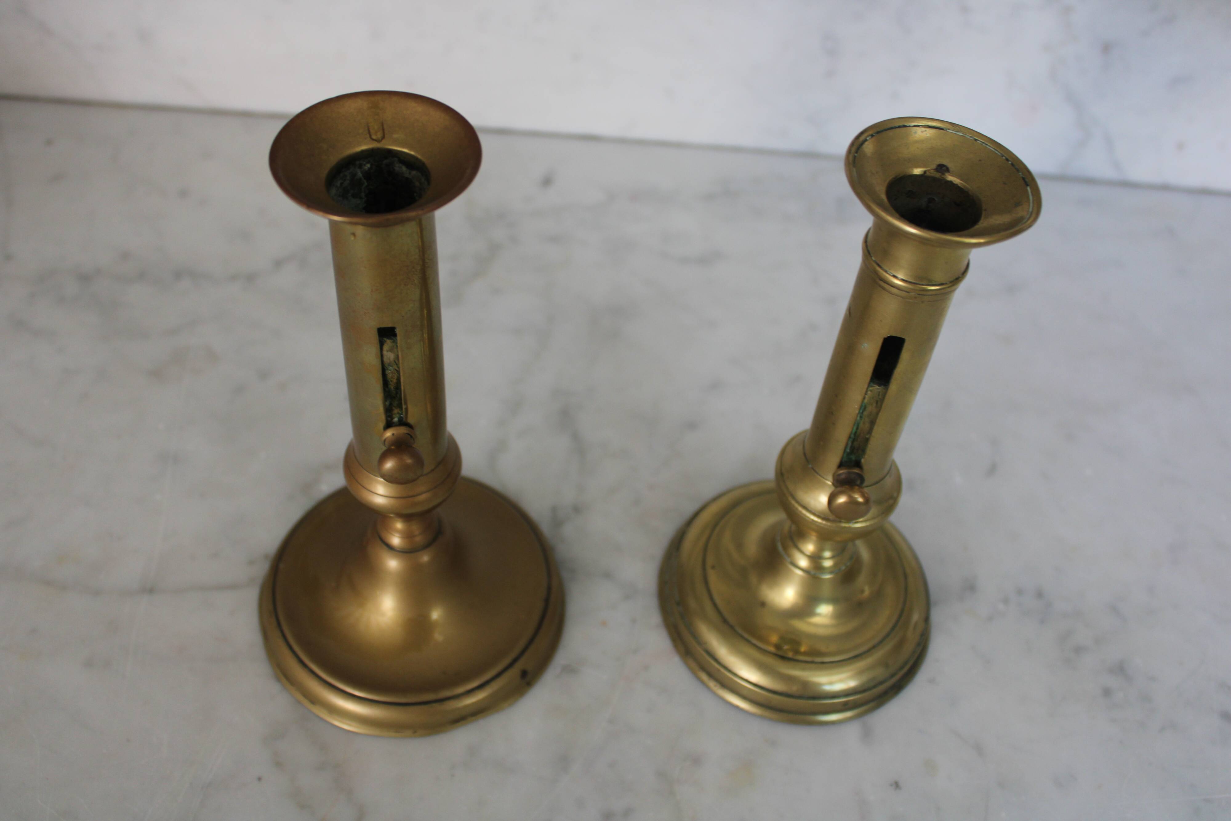 Pair of brass pusher candlesticks