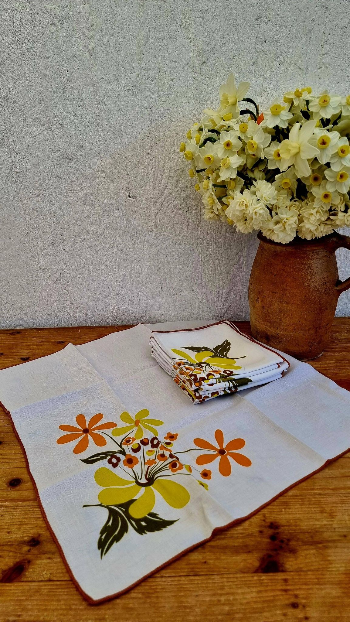 Set of 8 vintage 1970s table napkins with orange and yellow flowers.