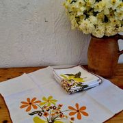 Set of 8 vintage 1970s table napkins with orange and yellow flowers.