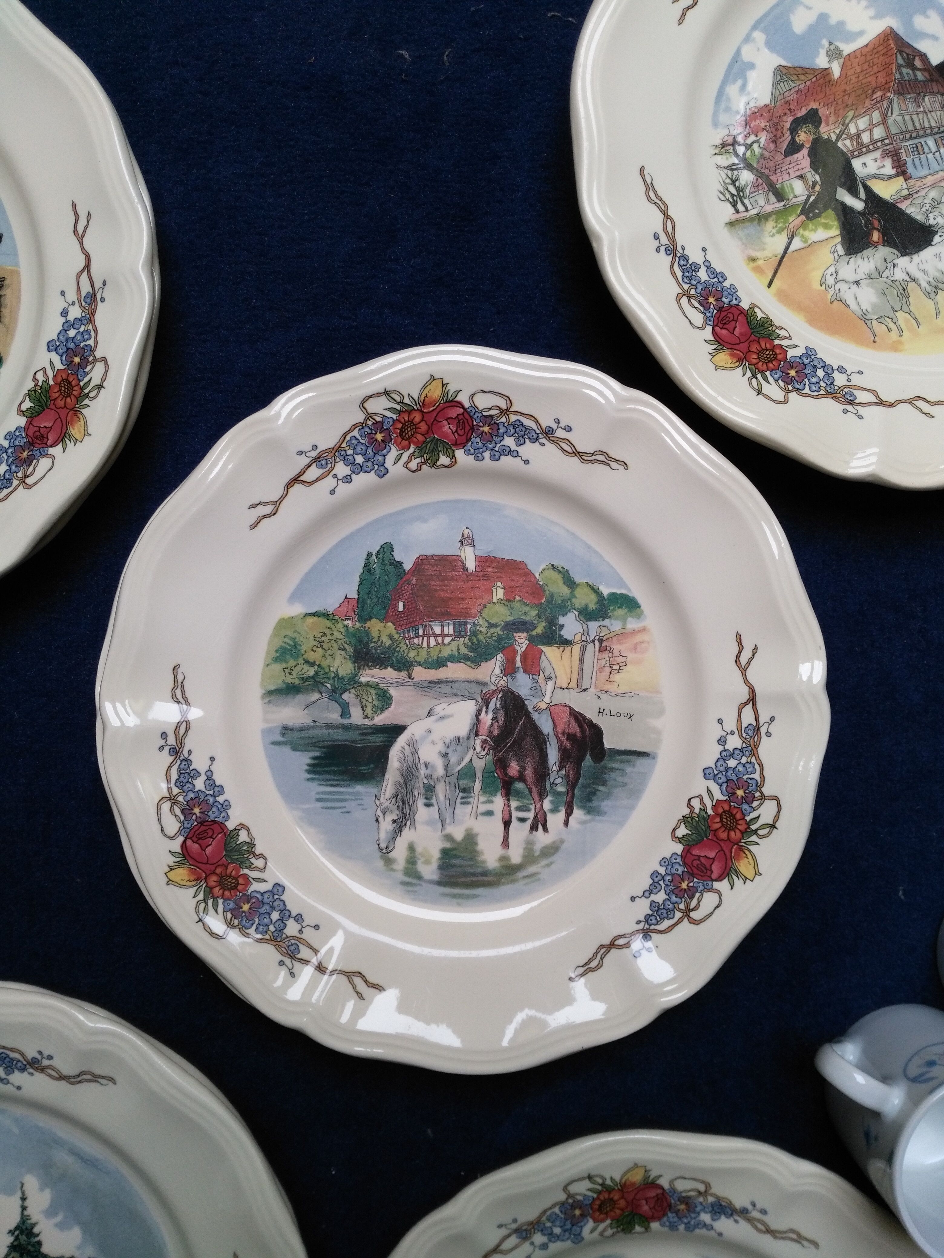 12 plates of the Obernai earthenware décor service signed Henri Loux