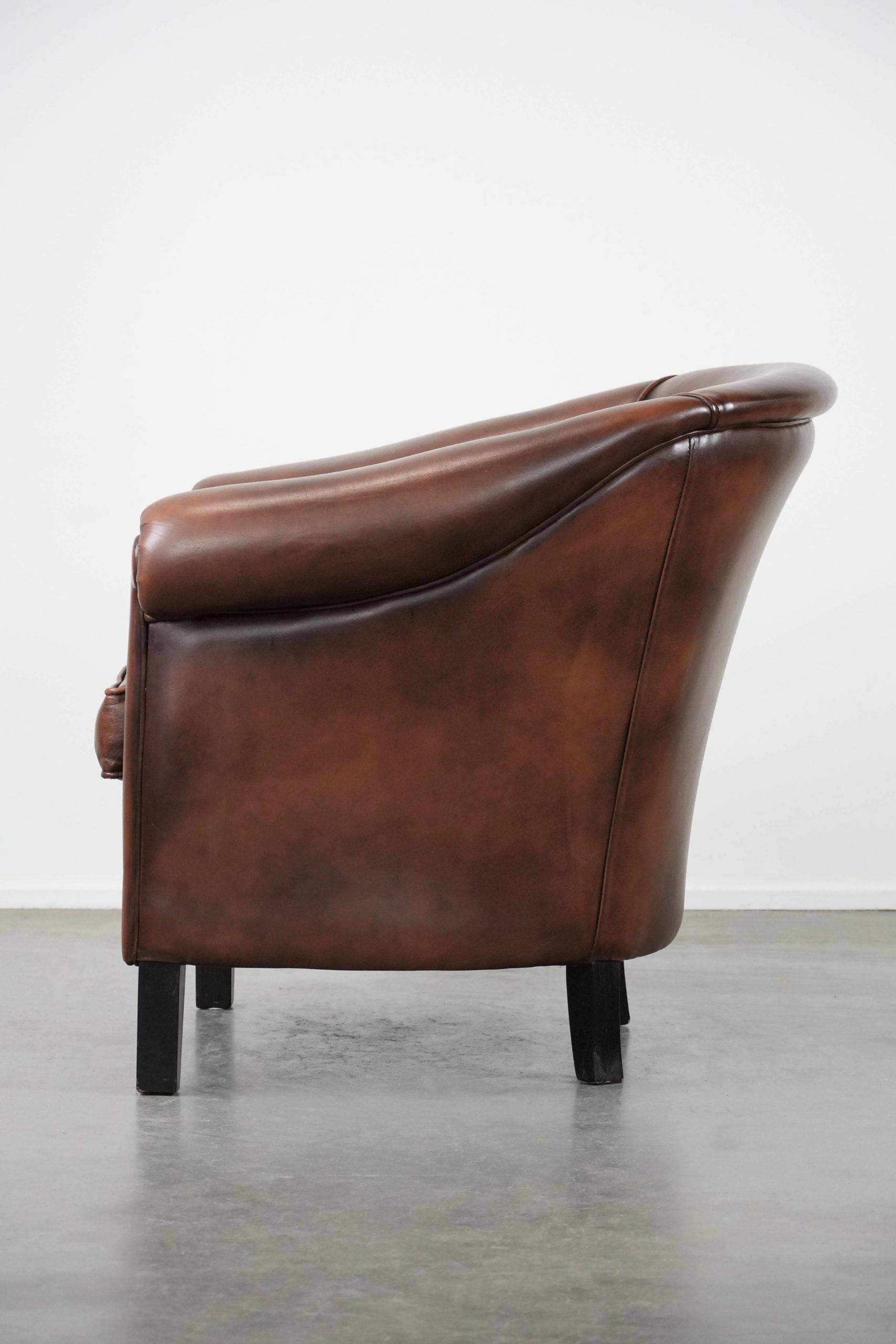 Great luxurious brown cowhide club armchair with matching piping