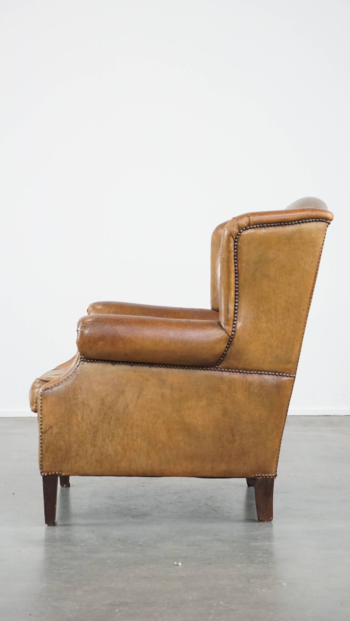 Patinated sheep leather wingback armchair