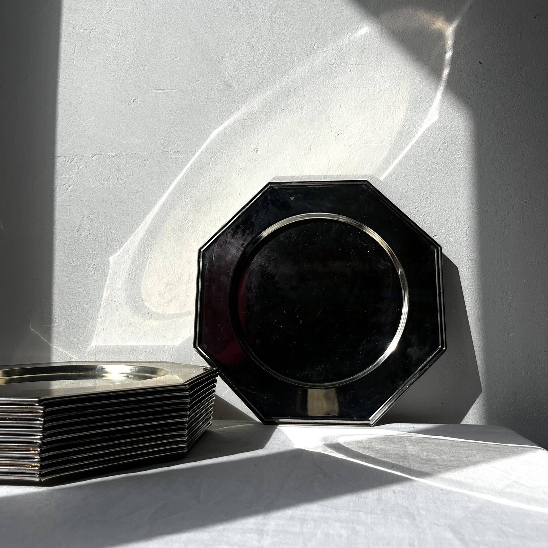 Many octagonal presentation plates in silver-plated metal.