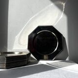 Many octagonal presentation plates in silver-plated metal.