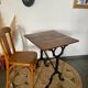 Bistro table with iron legs and raw wood top.