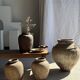 Very large grey and red terracotta pot with handles and rattan crossbars.