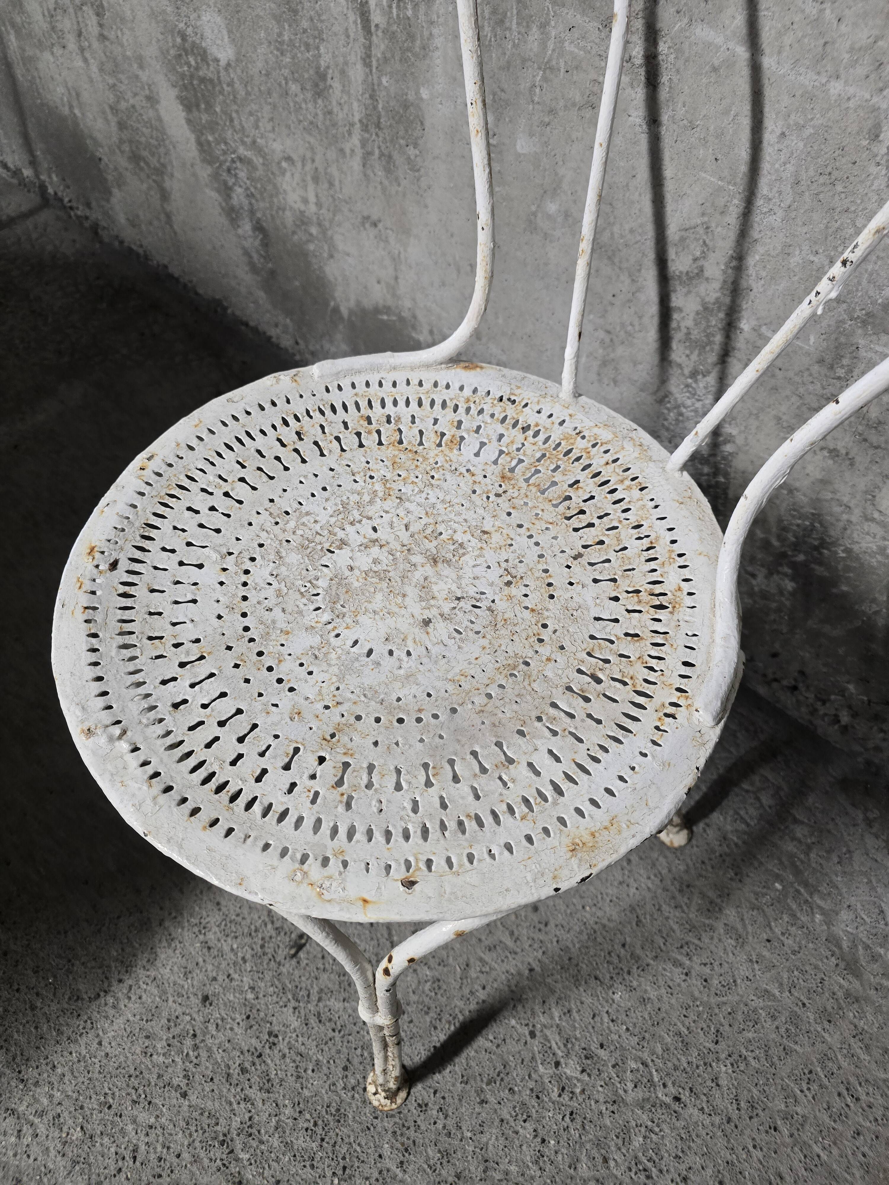 Antique painted wrought iron garden furniture, round table and four chairs.