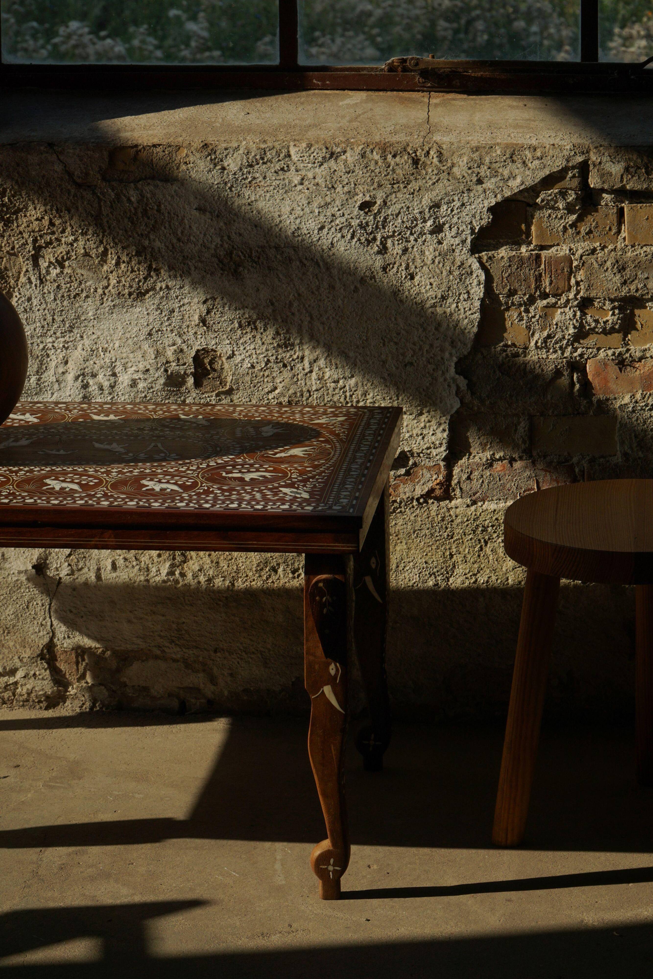 Vintage Indian teak coffee table inlaid with elephant motifs, mid-20th century.