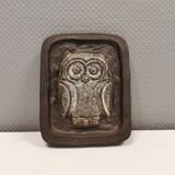 Small relief with a motif of an owl emerging from the back plate.