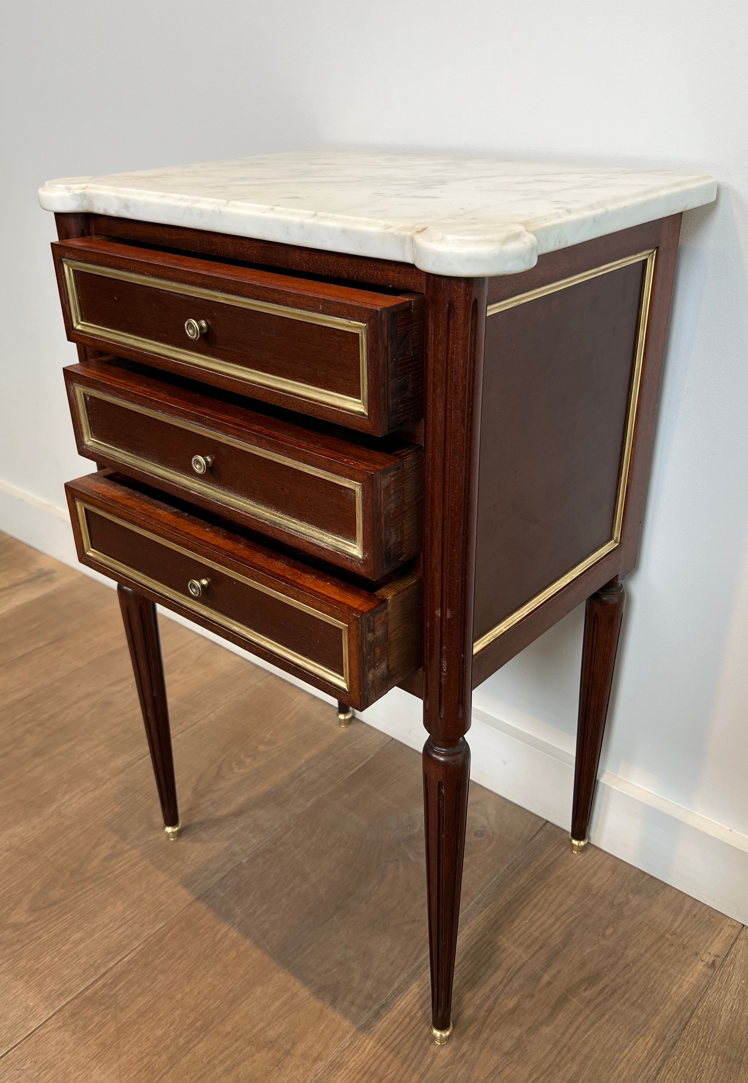 Pair of mahogany and brass side tables or bedside tables with Carrara marble tops.
