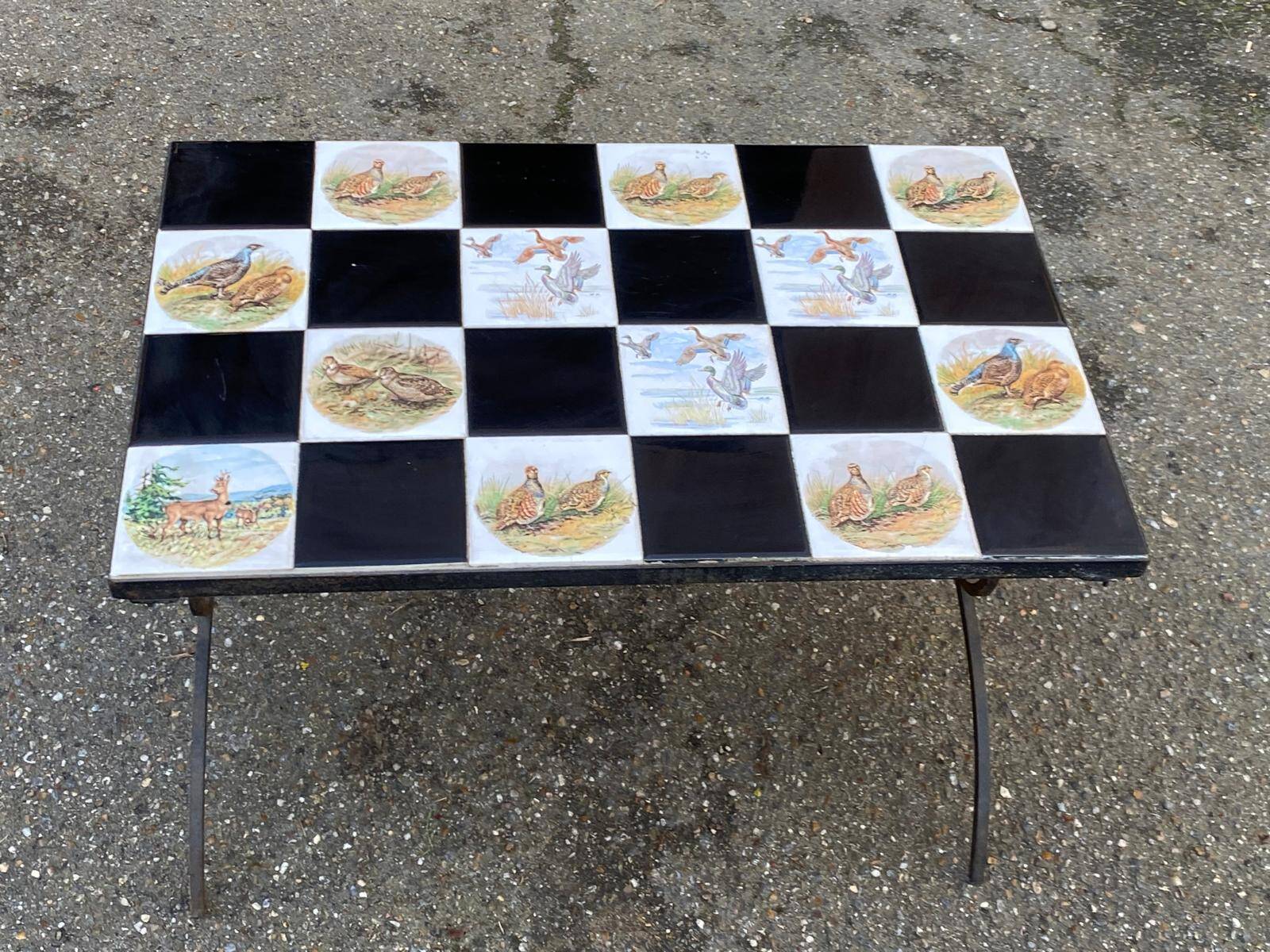 Vintage coffee table with black wrought iron and white tiles.