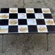Vintage coffee table with black wrought iron and white tiles.