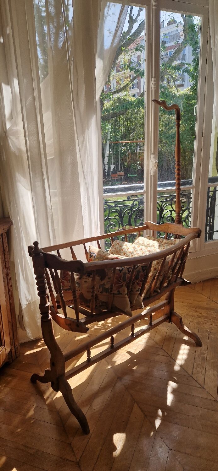 Wooden cradle in walnut with a sign collar at the top.