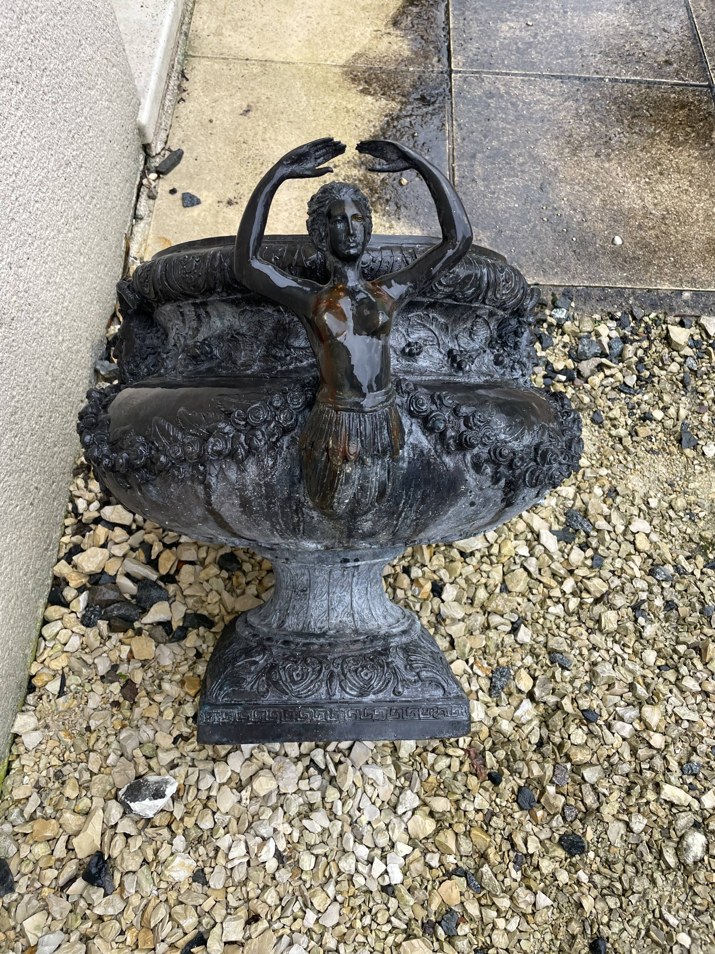 Cast iron vase decorated with mermaids.