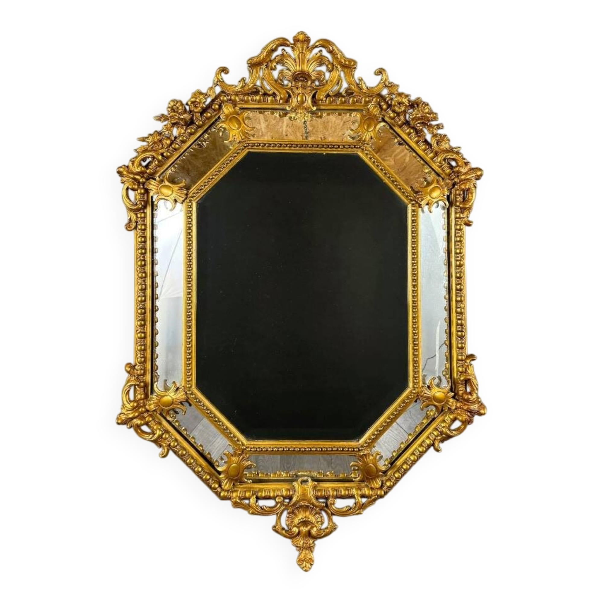Antique octagonal mirror in richly carved gilded wood, Louis XV style.