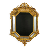 Antique octagonal mirror in richly carved gilded wood, Louis XV style.