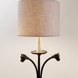 Wrought iron tripod floor lamp decorated with stylized animal heads