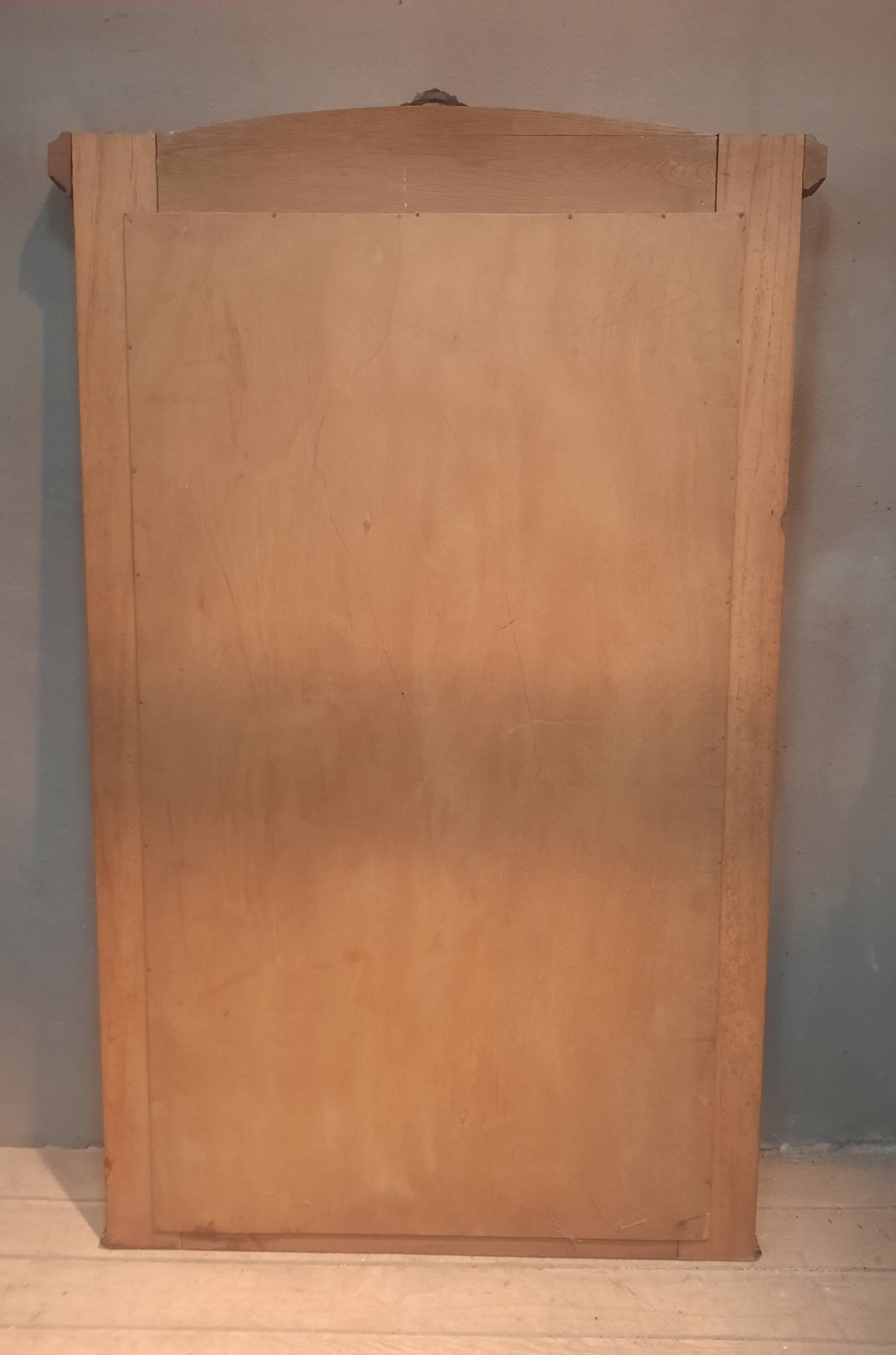 Bevelled mirror surrounded by a wooden frame.