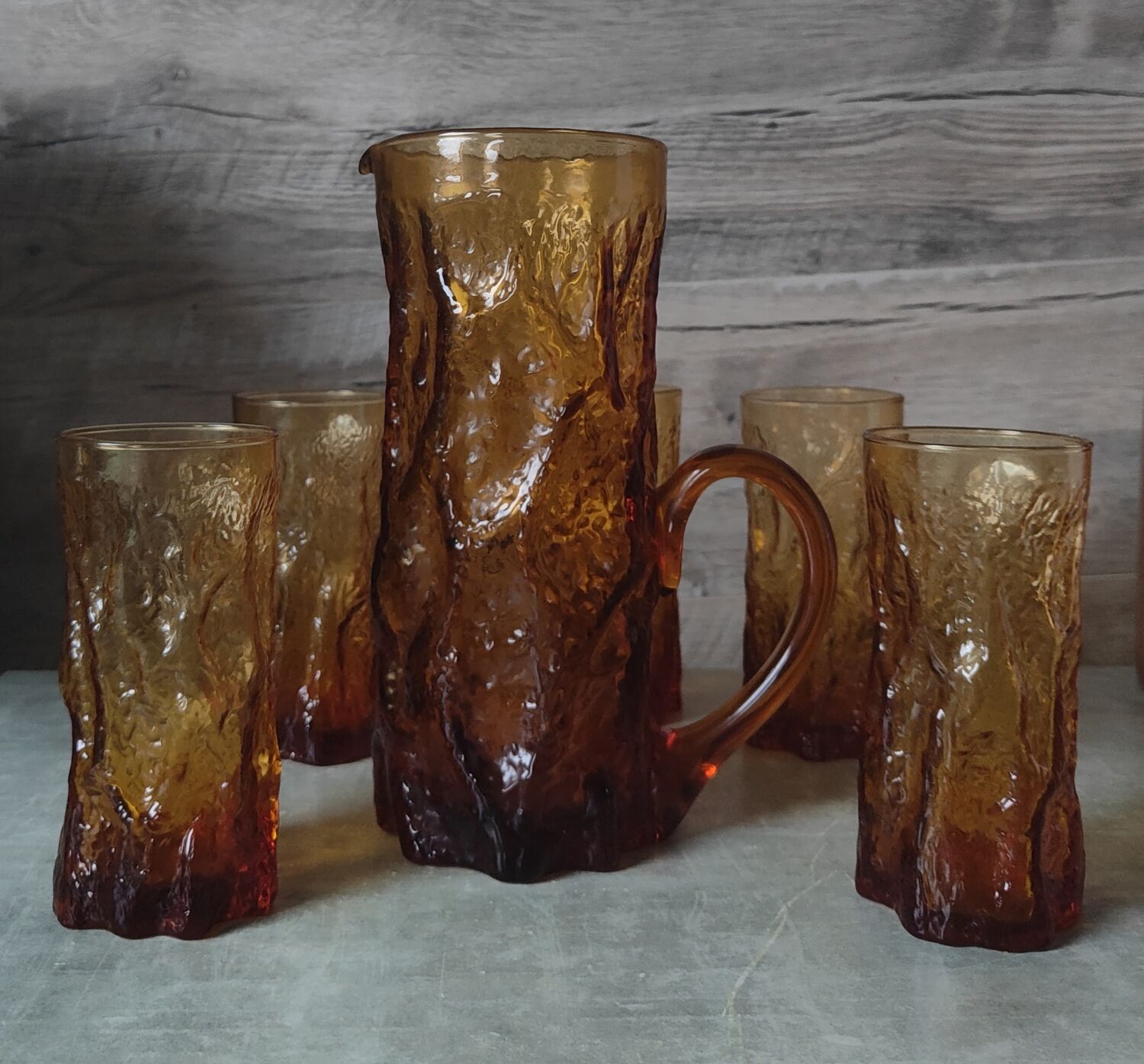 Pitcher and its glasses in amber glass
