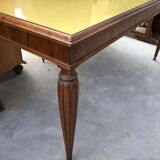 Dining table in the style of Paolo Buffa, made of brown wood with a tinted glass top.