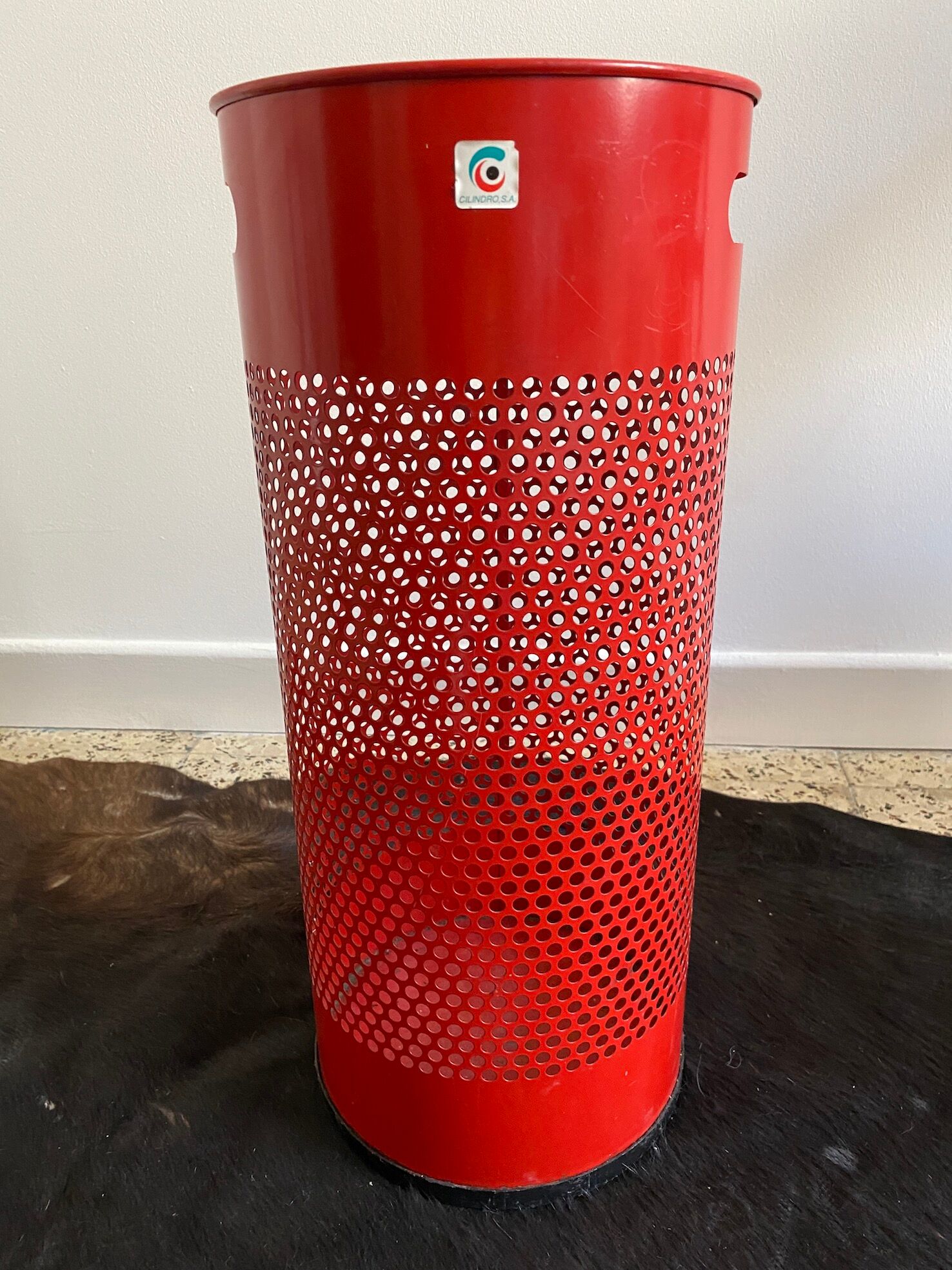 Vintage red umbrella holder in 80s perforated sheet metal or Italy trash can