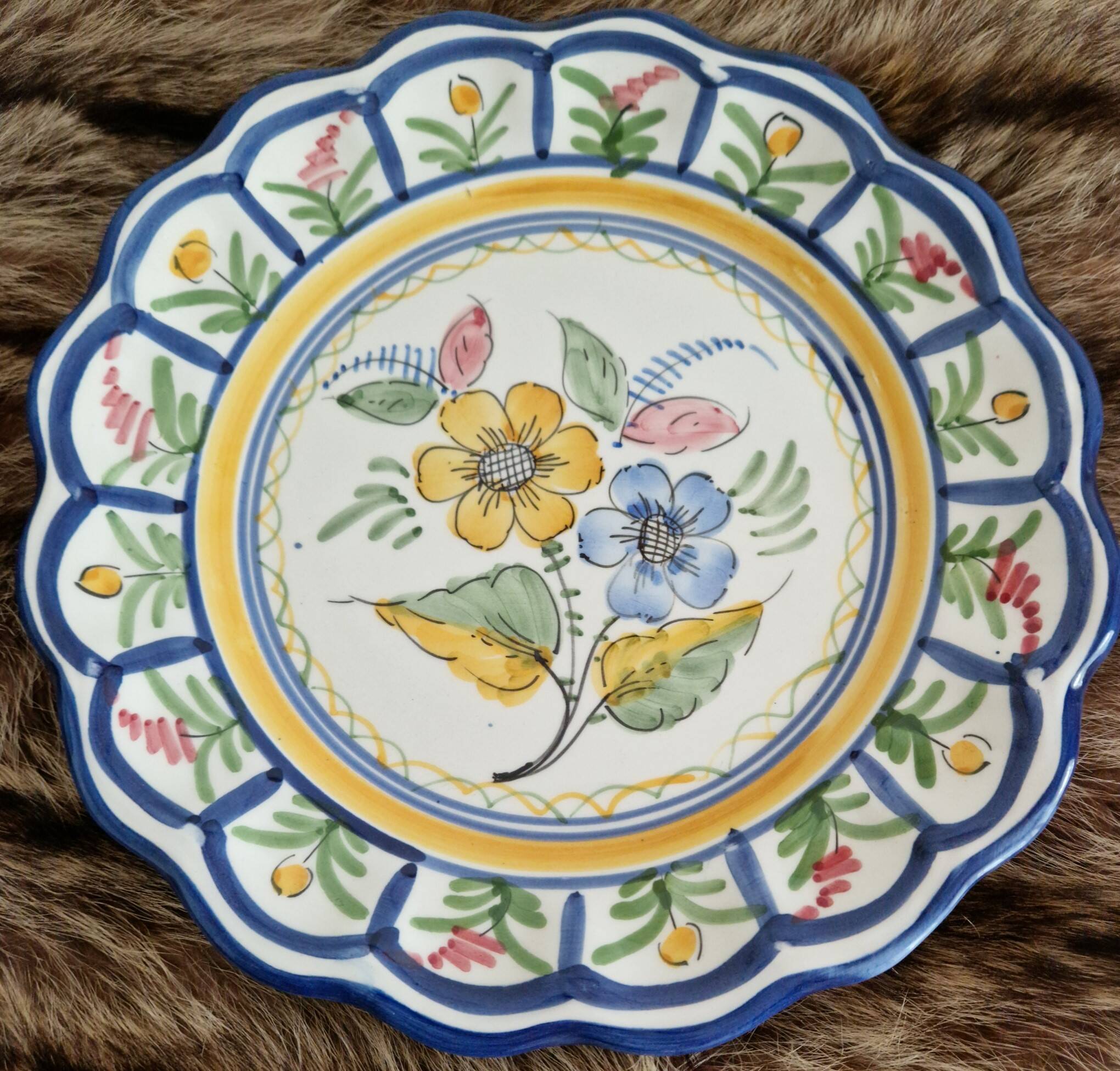Large hand-painted French faience plate with floral decoration in folk art style.