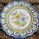 Large hand-painted French faience plate with floral decoration in folk art style.