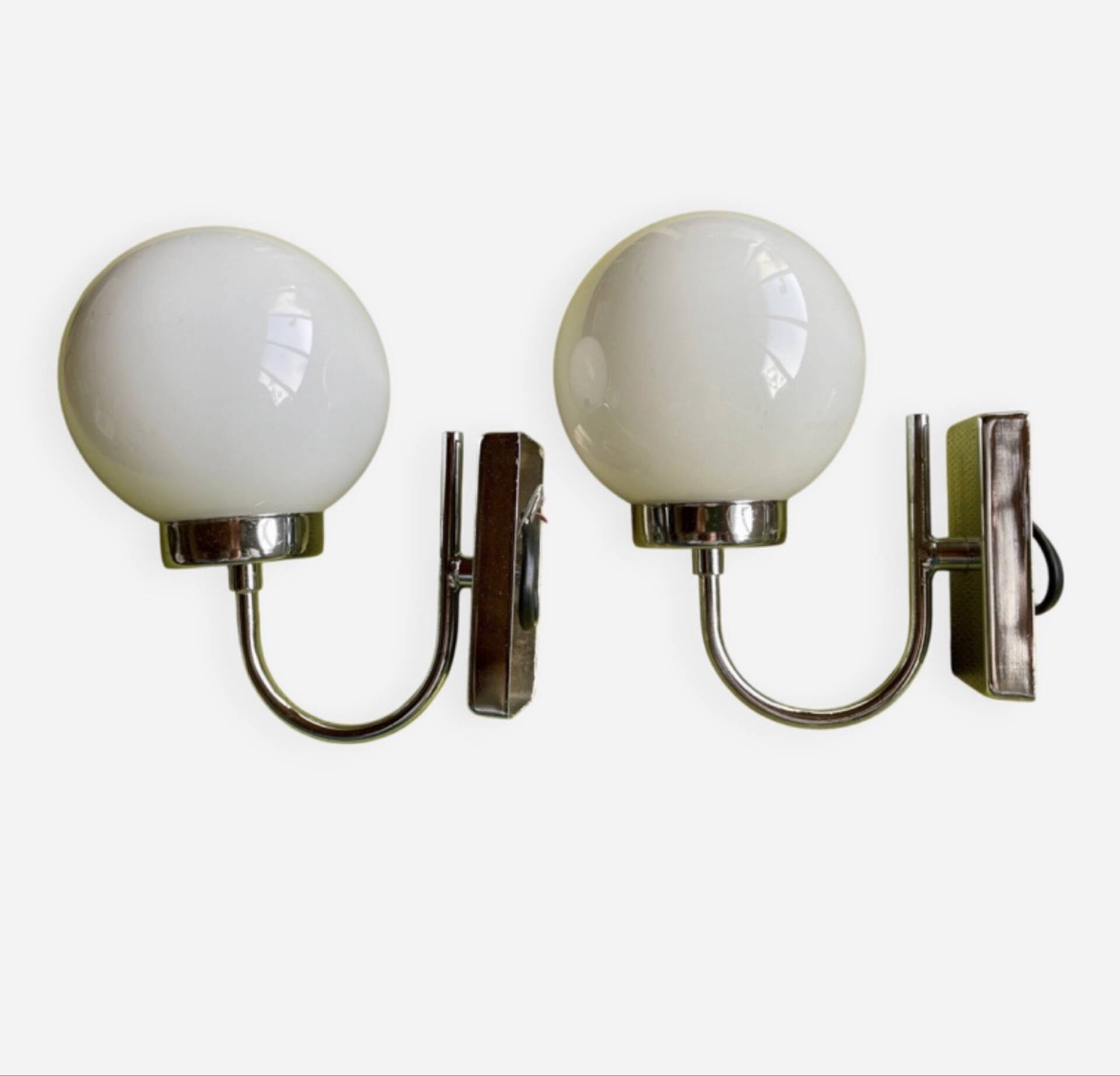 Pair of chrome metal wall lights with white glass globe.