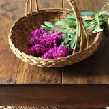 Round wicker basket with a rigid handle.